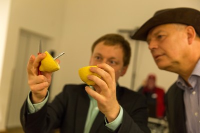 Magier Rene zeigt einem staunenden Zuschauer einen Geldschein in einer Zitrone