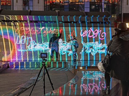Lichtgraffitikünstler besprüht Wand