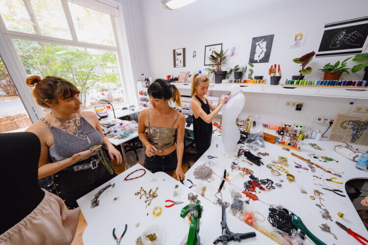 upcycling accessories and jewellery workshop white table with a lot of jewellery and participants designing their projects