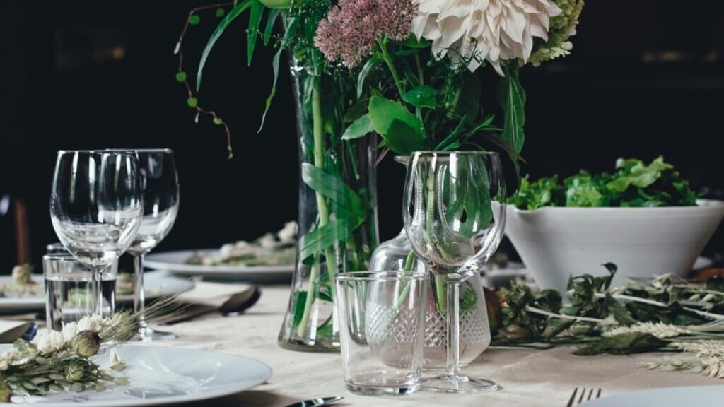 Tischdekoration mit Blumen und ein eingedeckter Tisch