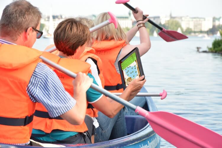 Drei Personen im Kanu mit iPAD
