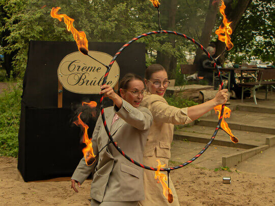 Frau Dr. Rauschenbacher und Frau Hartmann blicken durch den Feuer Hula Hoop (Fotos von Michael Medovyy)