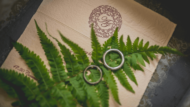 Einladungskarte mit einem Farnblatt und 2 Ringen darauf