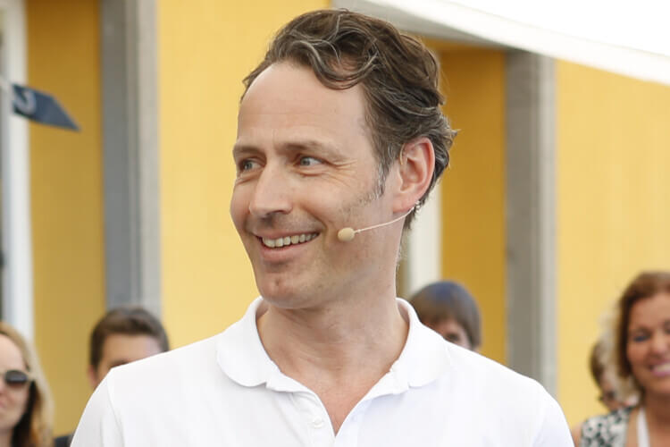 Mann mit Mikrofon lächelnd