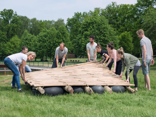 Floßbau Team trägt fertiges Floß
