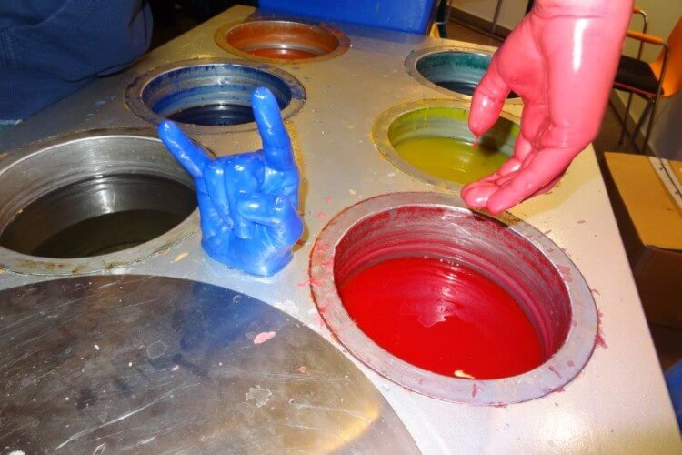 Hand aus Wax und echte Hand in roter Waxhülle