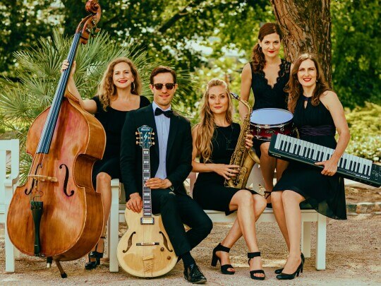 Musikerinnen von Evas Apfel mit Instrumenten: Schlagzeug, Gitarre, Saxophon, Kontrabass und Klavier