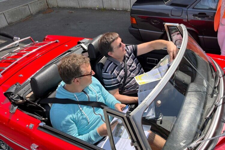 Leute in einem Oldtimer-Cabrio