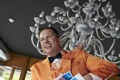 Moderator Julian Böhme vor einem Kronleuchter